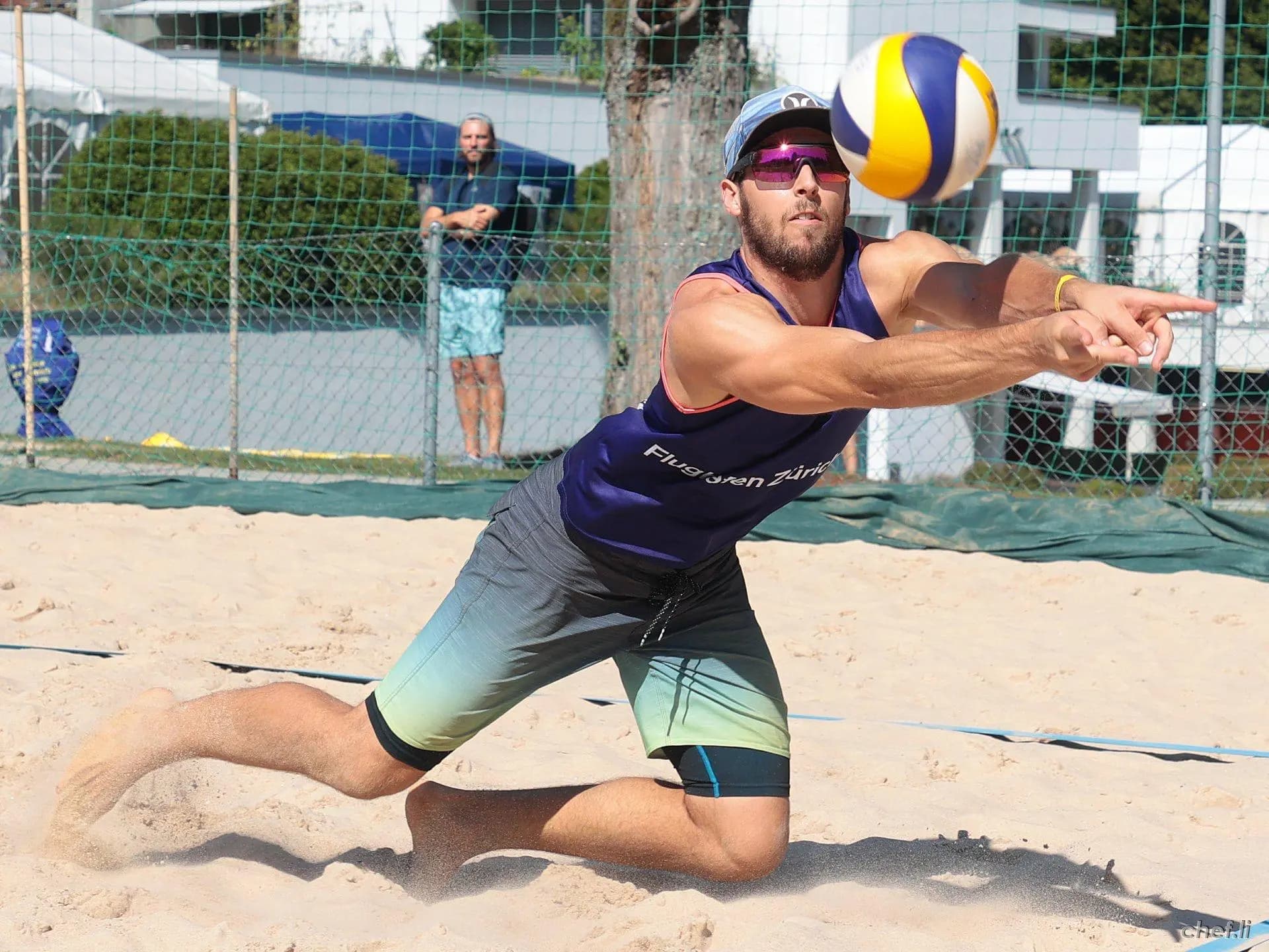 Spieler hechtet im Sand nach dem Ball
